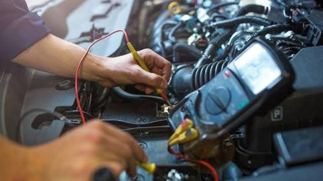 Modern auto shop exterior with large glass windows displaying car batteries and automotive products